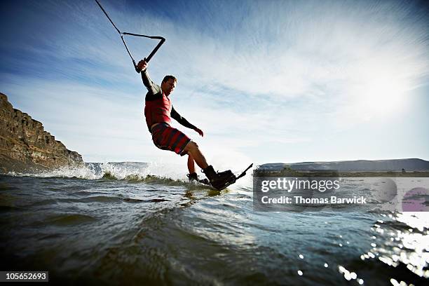 man carving turn on wakeboarding view from water - wakeboarden stockfoto's en -beelden