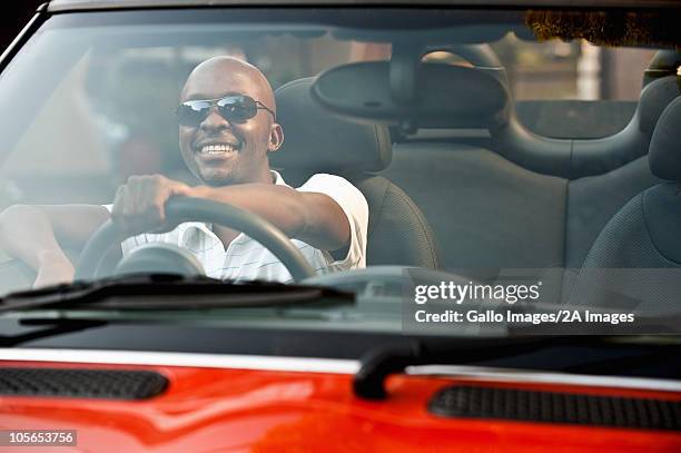 young man driving convertible car. - black car interior stock pictures, royalty-free photos & images