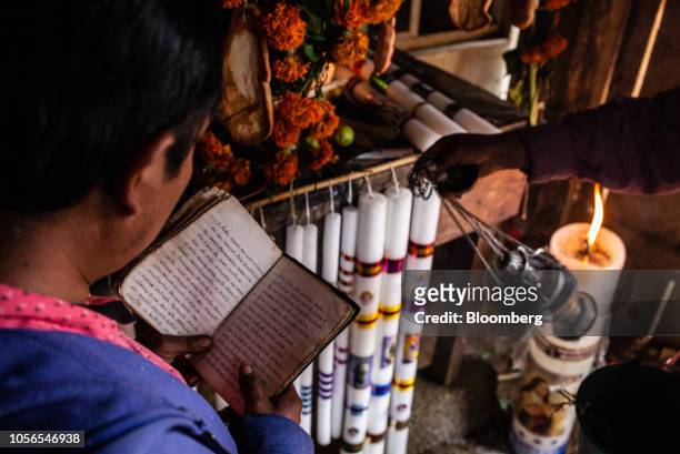 Family members spread incense and read prayers in front of an alter during Day of the Dead celebrations in the town of San Miguel Amoltepec Viejo,...