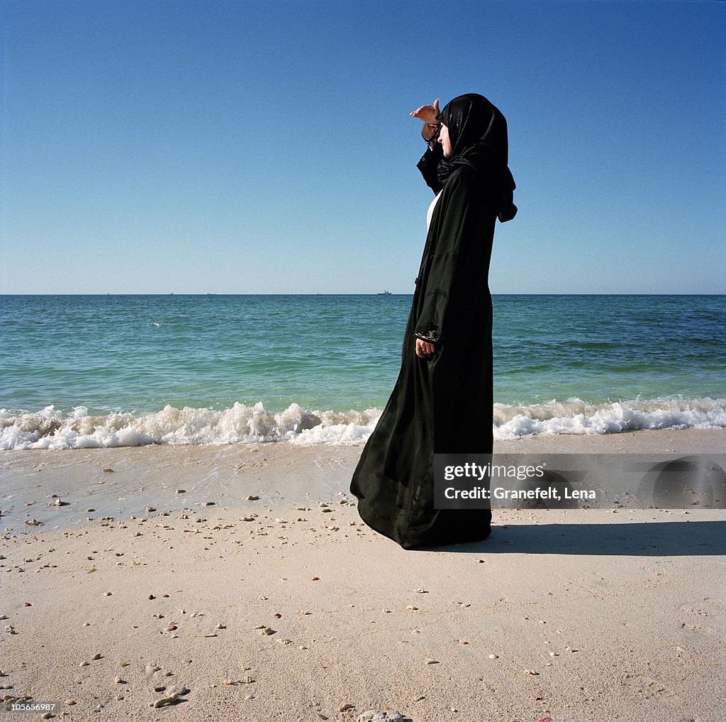 Woman in traditional clothing standing on beach