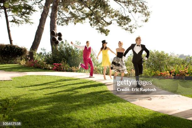 people in elegant clothing running on path in park - tuxedo party stock pictures, royalty-free photos & images