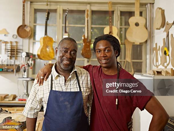 black craftsman in guitar workshop with son - father son business bildbanksfoton och bilder