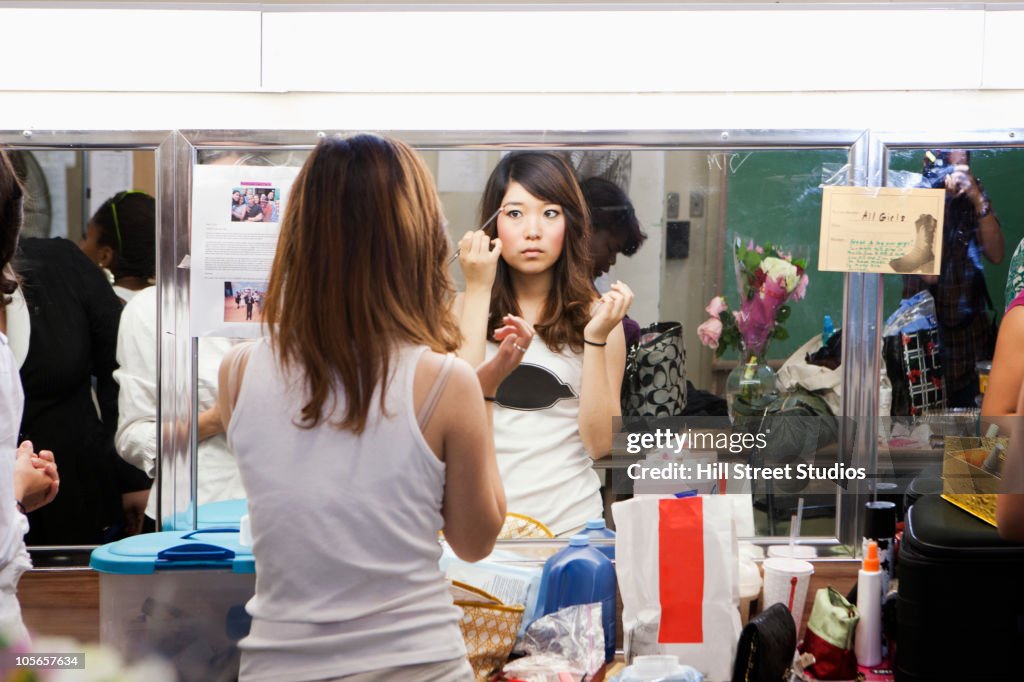 Korean girl putting makeup on backstage