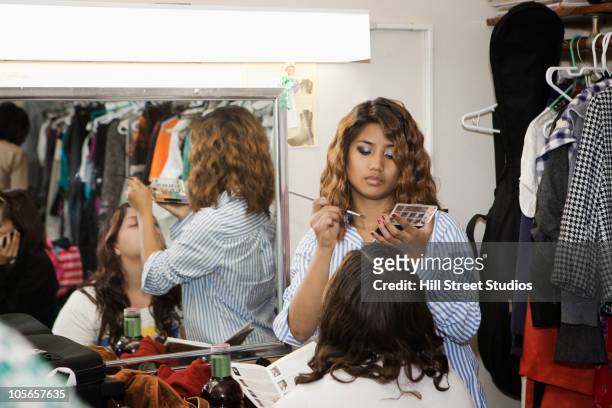 teenage girls putting makeup on backstage - vestuario entre bastidores fotografías e imágenes de stock