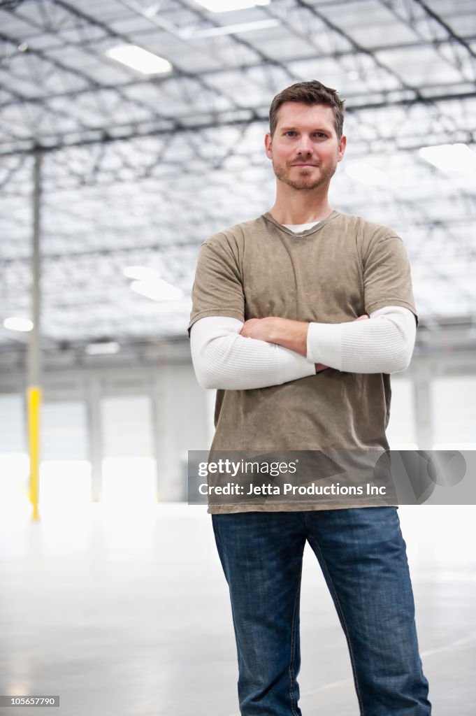 Caucasian man standing in empty warehouse