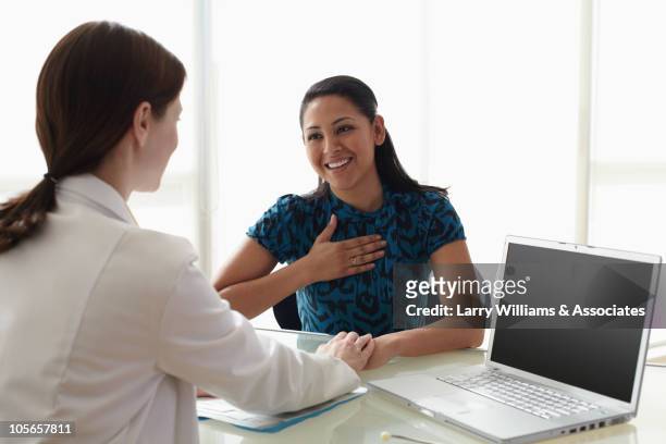 doctor talking to patient in doctor's office - clinic canada diversity stock-fotos und bilder