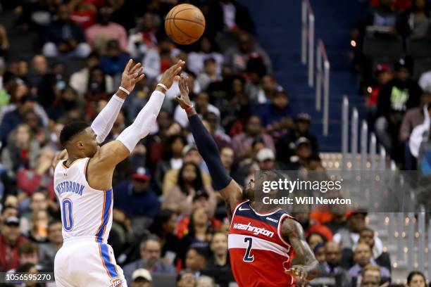 Russell Westbrook of the Oklahoma City Thunder shoots over John Wall of the Washington Wizards during the second half at Capital One Arena on...