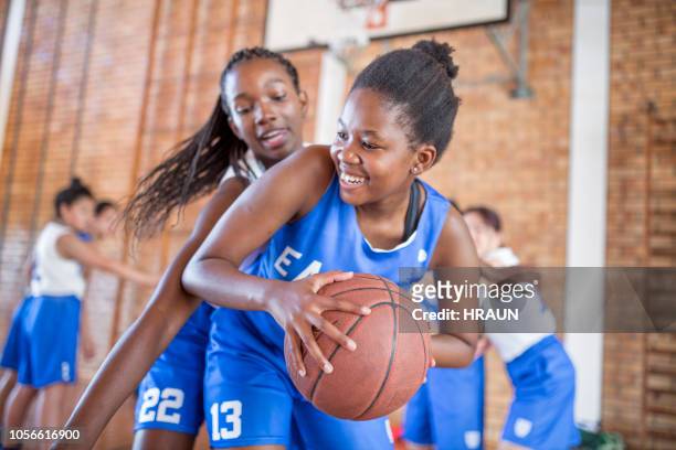 female defending basketball from opponent - teenage girls stock pictures, royalty-free photos & images