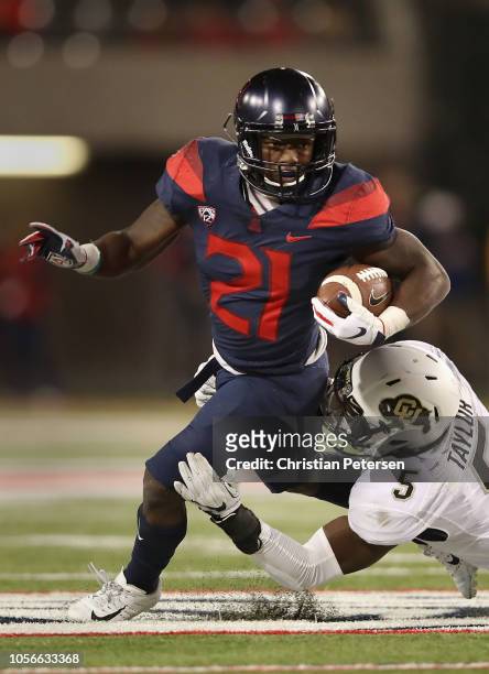 Running back J.J. Taylor of the Arizona Wildcats rushes the football against linebacker Davion Taylor of the Colorado Buffaloes during the second...