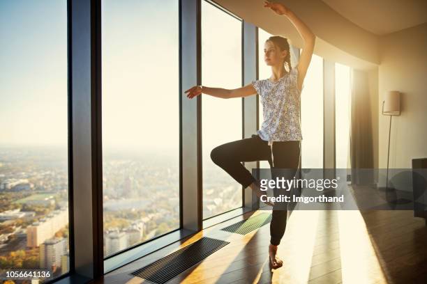 teenage practicing dancing at modern apartment - girl yoga stock pictures, royalty-free photos & images