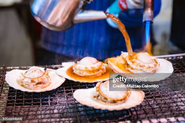 grilled scallops at tsukiji fish market, tokyo, japan - tsukiji fish market stock pictures, royalty-free photos & images