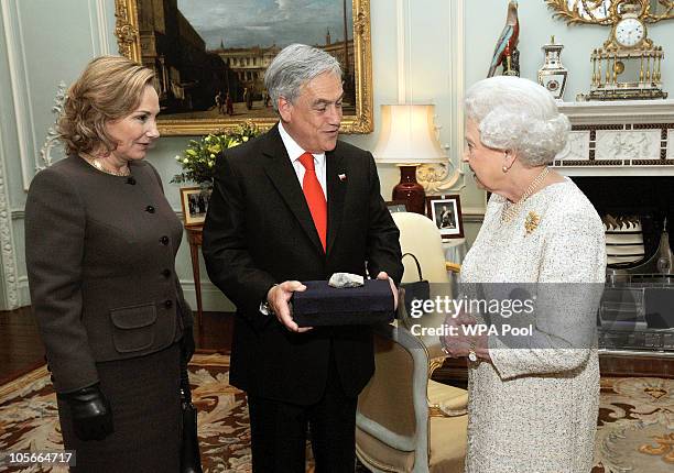 Queen Elizabeth II is given a piece of rock from the San Jose Mine by the President of Chile, Sebastian Pinera, accompanied by his wife Cecilia Morel...