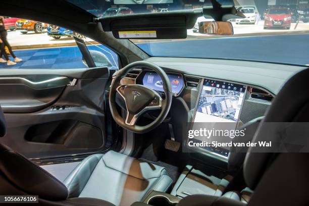 Interior on a Tesla Model X full electric luxury crossover SUV car with a large touch screen and carbon look dashboard on display at Brussels Expo on...