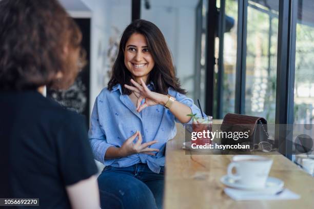 two young woman speak in sign language - turkish people stock pictures, royalty-free photos & images