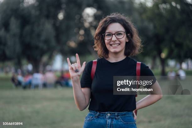 mujer joven diciendo i love you en lenguaje de señas - american sign language fotografías e imágenes de stock