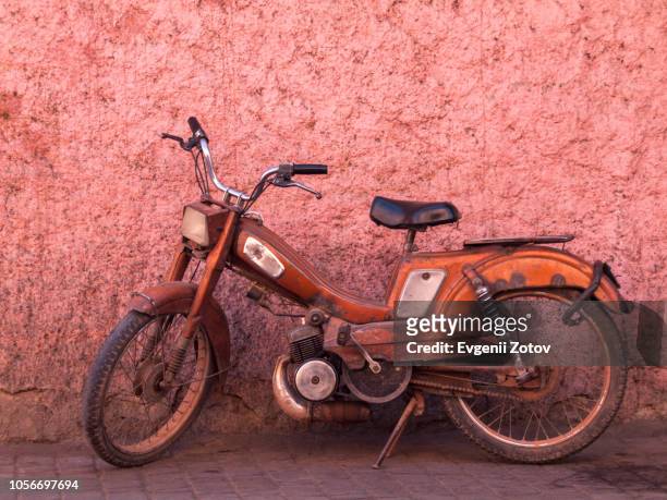 old orange moped in front of pink wall in marrakesh, morocco - old motorcycles bildbanksfoton och bilder