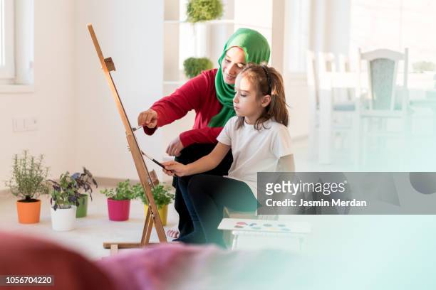 Female and little kid painting at home