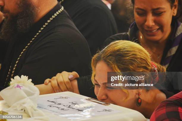 Dpatop - 03 November 2018, Egypt, Minya: A woman grieves at the Church of Great Martyr Prince Tadros next to the coffin of one of the victims who...