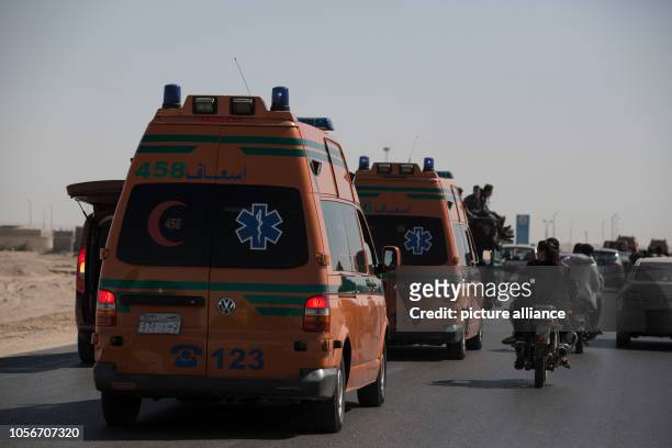 November 2018, Egypt, New Minya: Ambulances carrying coffins head to the Coptic graves during the funeral of the victims who were killed during a gun...