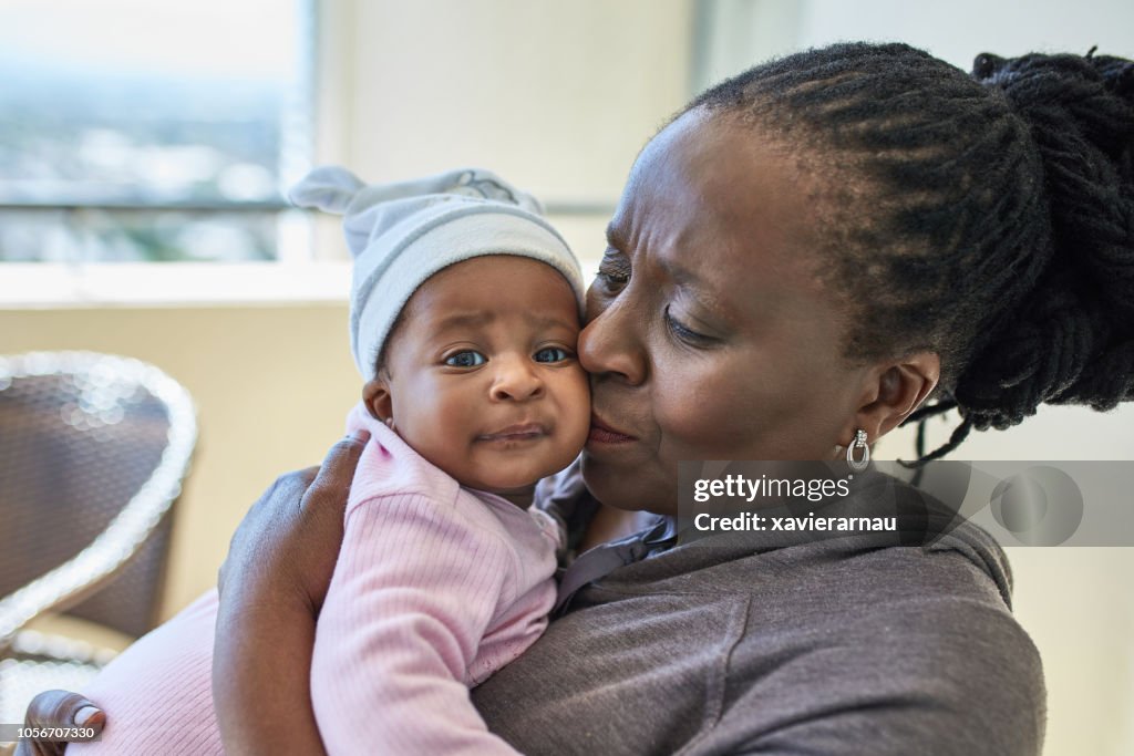 African grandmother kissing her granddaughter