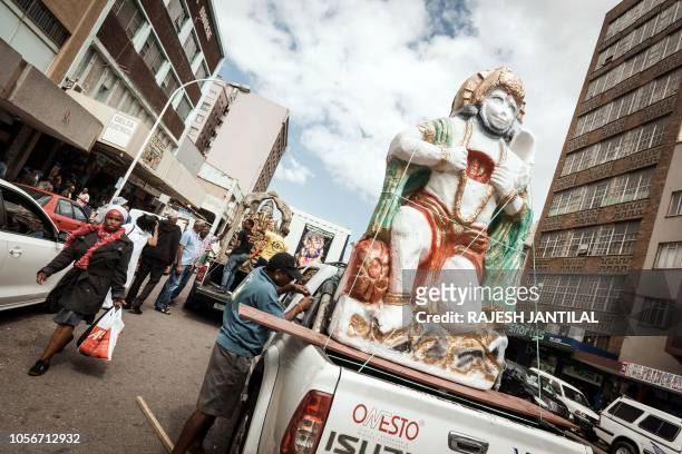 Man ties up an hindu god statue on the back of a truck ahead of a street parade during the preparations of the two-days celebrations for the Diwali...