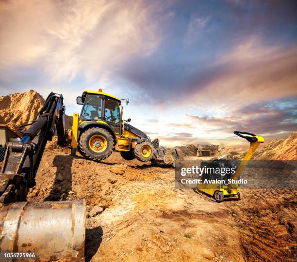 large excavator and plate compactor on a construction site. - plate compactor stock pictures, royalty-free photos & images