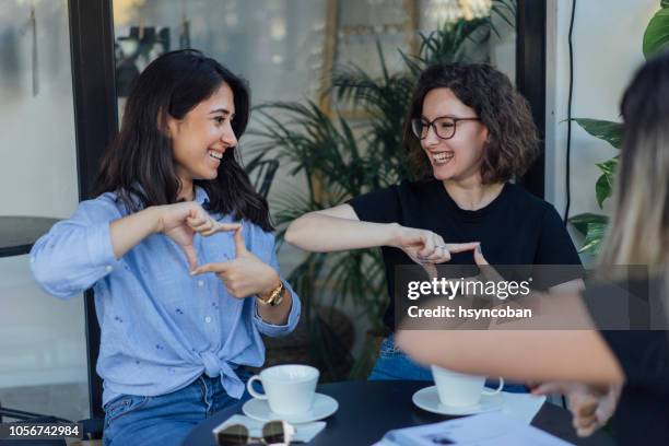 jóvenes aprenden a hablar en lengua de signos - american sign language fotografías e imágenes de stock