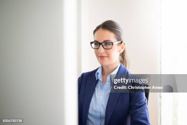 business woman with glasses using computer - blue suit stock pictures, royalty-free photos & images