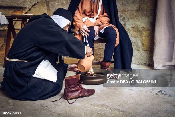 Knight of the Knights Hospitallers washing aHoly Land pilgrim's feet, 13th century. Historical reenactment in Malta.
