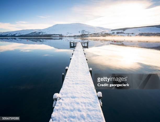 snow covered jetty on loch earn in scotland - scotland mountains stock pictures, royalty-free photos & images