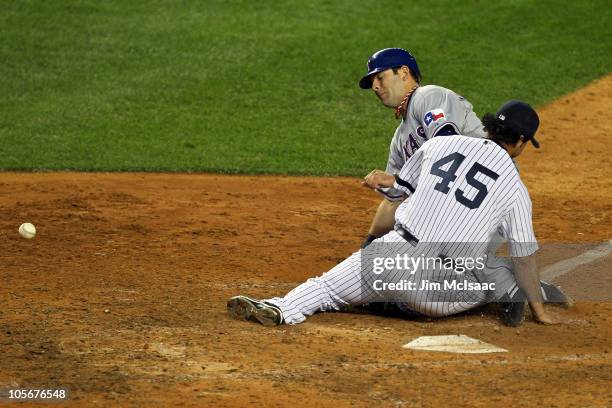 Mitch Moreland of the Texas Rangers scores on a wild pitch against Sergio Mitre of the New York Yankees in the top of the ninth inning of Game Three...