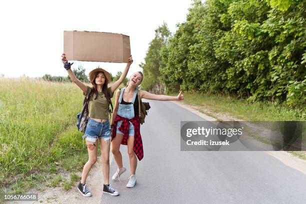 兩個時髦的女孩搭便車在一起 - hitchhiking 個照片及圖片檔