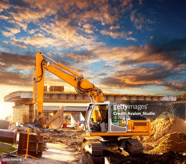 excavator on a road construction site - bridge built structure stock pictures, royalty-free photos & images