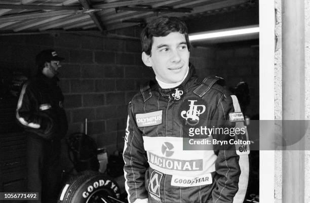 Formula One Grand Prix racing driver Ayrton Senna, driving for Lotus-Renault in the 97T John Player Special , stands inside his pit lane garage...