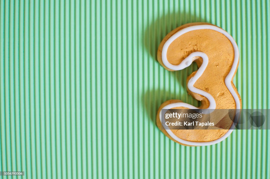 A flat lay of golden colored number 3