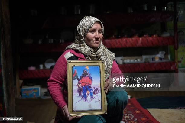 In this picture taken on May 5 Gul Dana, widow of Jahan Baig, a Pakistani mountaineer who died in the 2008 K-2 disaster, holds a photograph of her...