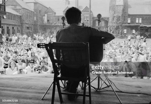 View, from behind, of American musician Bob Dylan as he plays acoustic guitar during a performance at the Newport Folk Festival, Newport, Rhode...