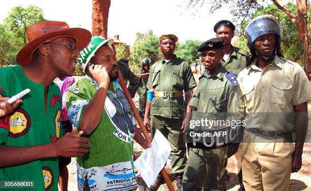 Zambia Police officers prevent the Patriotic Front national youth secretary, Eric Chanda and the Patriotic Front and United Party for National...