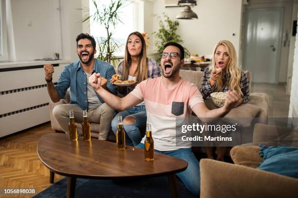 friends watching sport on tv. - awards winners room stock pictures, royalty-free photos & images