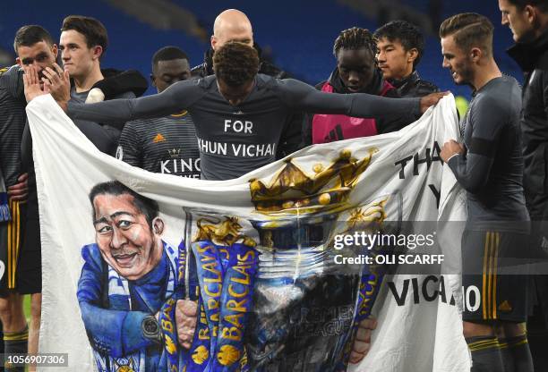 Leicester City's English midfielder James Maddison and Leicester City's English midfielder Demarai Gray hold a banner showing Leicester City Chairman...