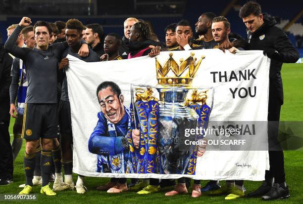 Leicester City's English midfielder James Maddison and Leicester City's English midfielder Demarai Gray hold a banner showing Leicester City Chairman...