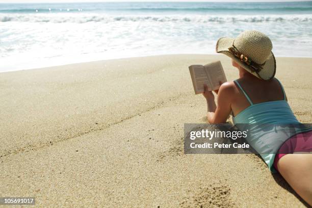 woman reading book on beach - woman on beach reading stock pictures, royalty-free photos & images