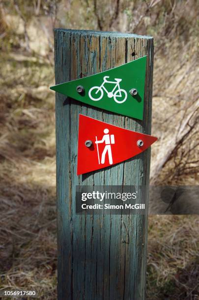 hiking and mountain bike track signs on a wooden post - wooden sign post stockfoto's en -beelden