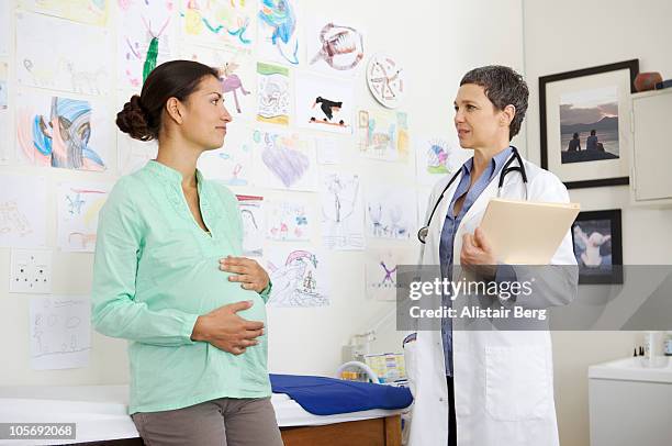 doctor consulting with pregnant woman - patientin stock-fotos und bilder