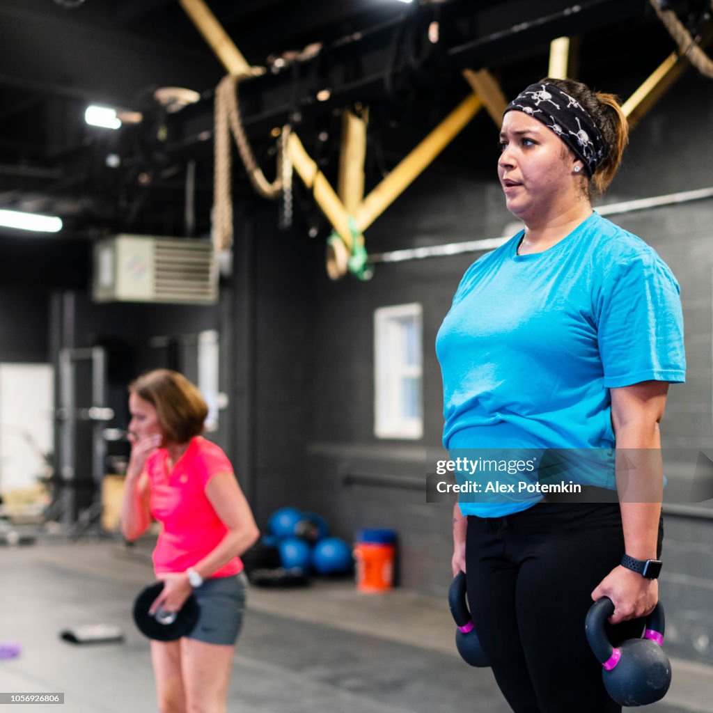Die junge, Körper-positiven Latino-Frau Step-up mit Gewicht-Training in der Turnhalle zu tun