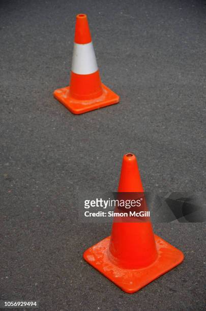 traffic cones near road construction on a suburban street - safety cone stock-fotos und bilder