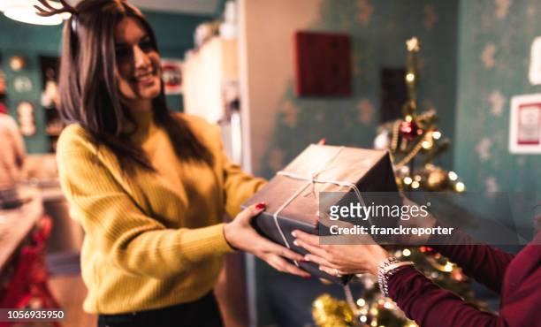 vrienden uitwisselen kerstcadeautjes - geven stockfoto's en -beelden