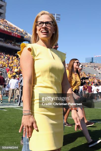 Democrat U.S. Senate candidate Kyrsten Sinema participates in the pregame coin toss before the game between the Utah Utes and the Arizona State Sun...