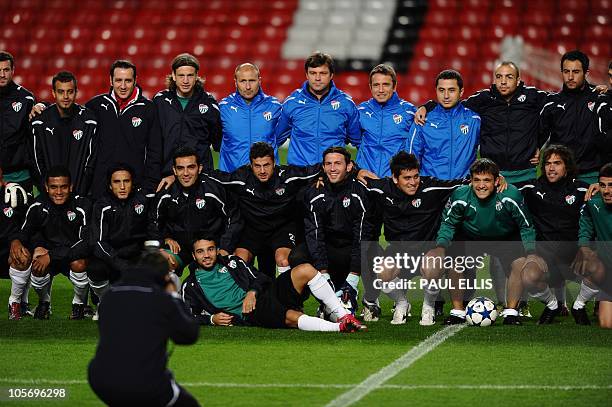 Bursaspor manager Ertugrul Saglam poses with his team ahead of a training session at Old Trafford in Manchester, north-west England on October 19,...