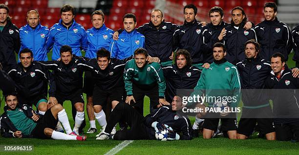 Bursaspor manager Ertugrul Saglam poses with his team ahead of a training session at Old Trafford in Manchester, north-west England on October 19,...